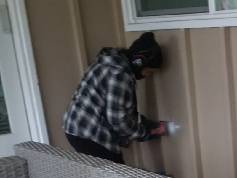 Professional electrician installing an exterior outlet in Durand